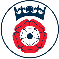 circular emblem featuring a red and white rose design with a crown above symbolizing tradition and heritage