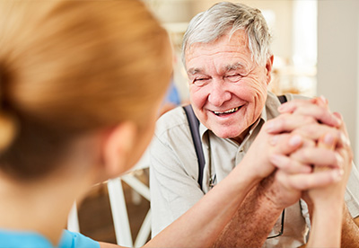 smiling elderly man engaged in arm wrestling with a young person promoting interaction and fun activities for seniors aged 14 and up
